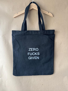 Black tote bag with ‘Zero fucks given’ embroidered in white.