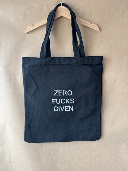 Black tote bag with ‘Zero fucks given’ embroidered in white.