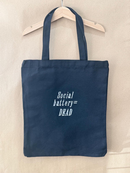 Black tote bag with ‘Social battery= DEAD’ embroidered in white.