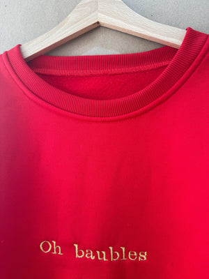 Christmas jumper in red, ‘Oh baubles’ embroidered in gold
