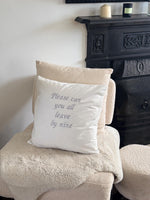 White cushion cover with ‘please can you all leave by nine’ embroidered in silver