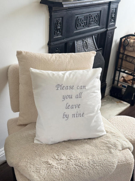 White cushion cover with ‘please can you all leave by nine’ embroidered in silver