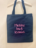 Black tote bag with ‘Messy but Iconic’ embroidered in neon pink