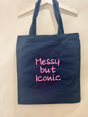 Black tote bag with ‘Messy but Iconic’ embroidered in neon pink